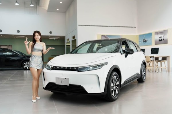 A woman posing in front of a white n7 LUXGEN car