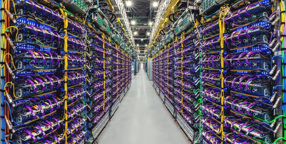 Image of a data center aisle with rows of servers. 