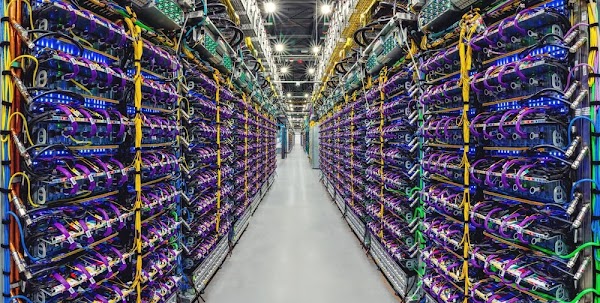 Image of a data center aisle with rows of servers. 