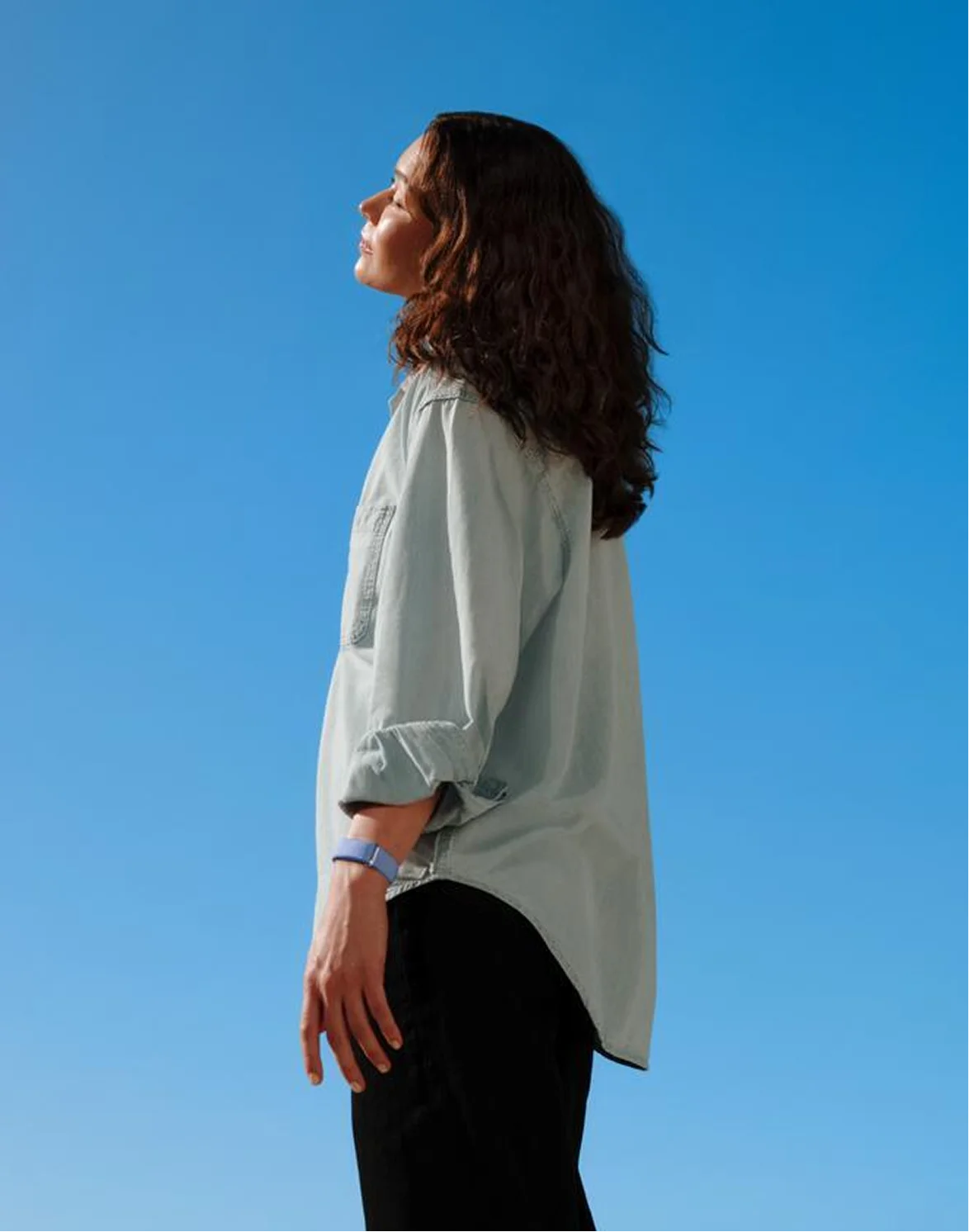 Image of woman wearing Google Fitbit Air. 