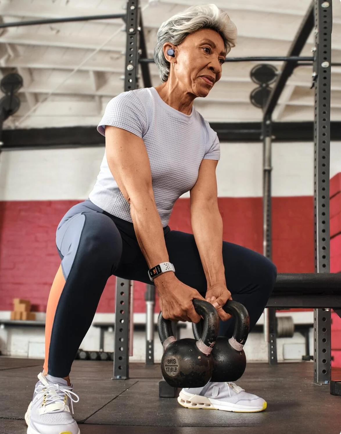 Image of woman lifting weights wearing Fitbit Charge 6 