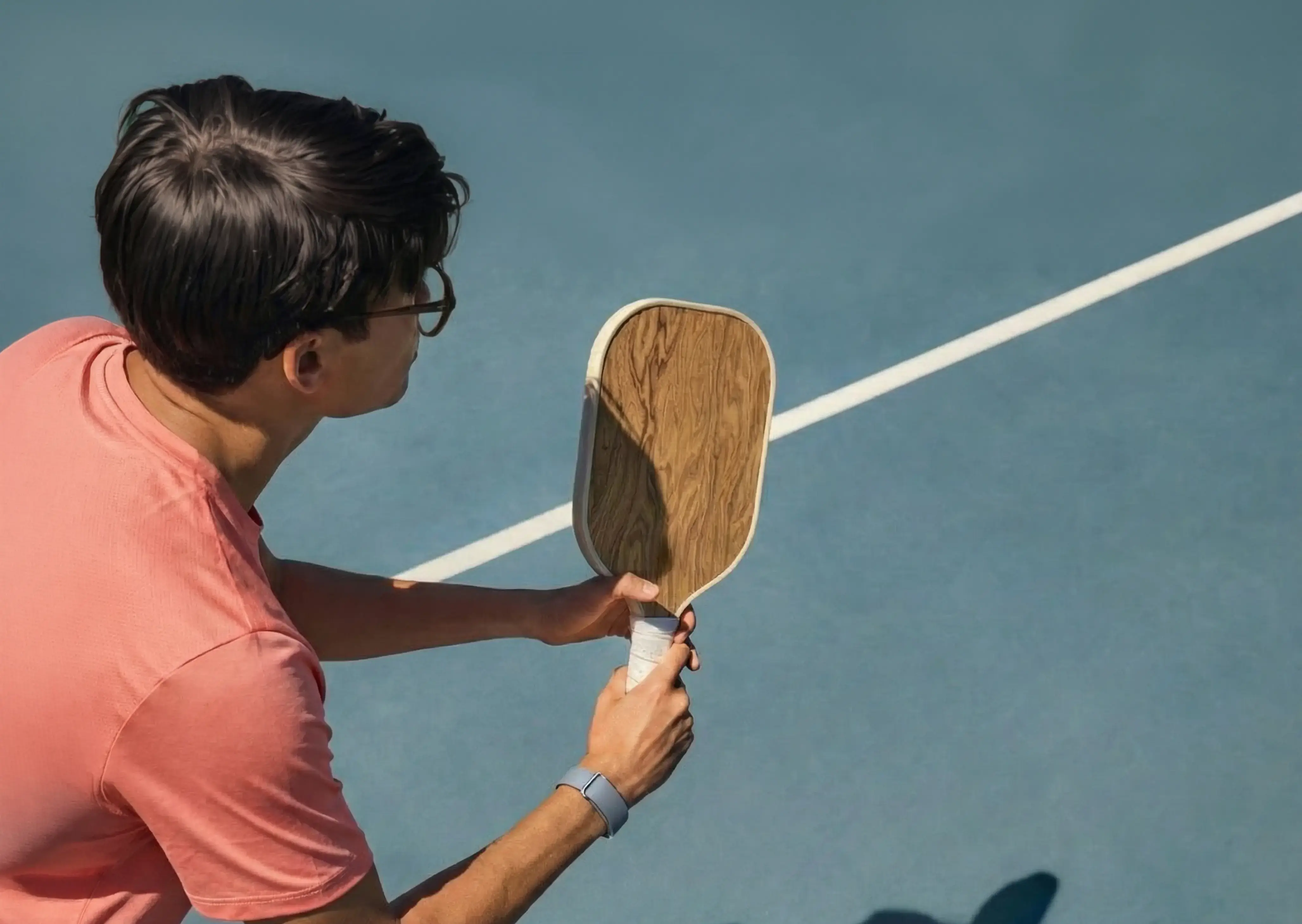 Image of man playing pickleball wearing Google Fitbit Air