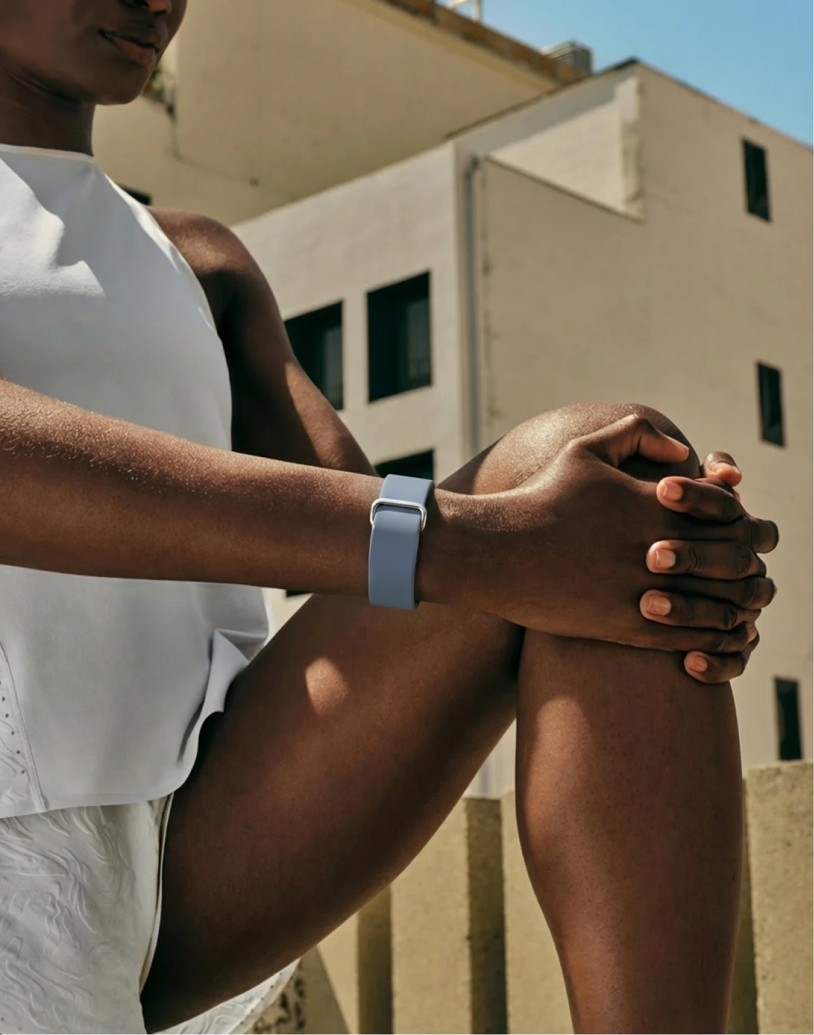 Image of woman stretching wearing Google Fitbit Air