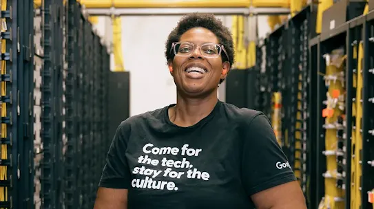 Person smiling while standing in a data center