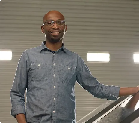 Founder Seyi Fabode smiles at the camera inside his garage-turned-office.