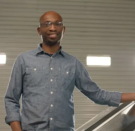 Founder Seyi Fabode smiles at the camera inside his garage-turned-office.