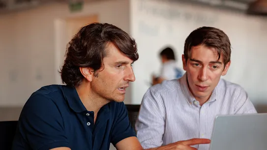 Two men sitting in front of a computer