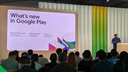 A speaker presents the “What’s new in Google Play” session at Google I/O 2025, with a slide highlighting updates to the Play Store and a seated audience watching the keynote.