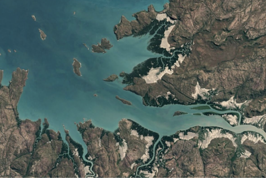 Flugaufnahme von brauner Landmasse neben türkisfarbenem Gewässer