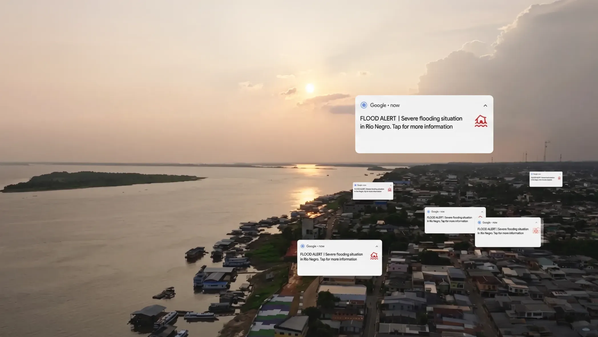 A photograph of a town on the coast. Overlaid on the photograph are flood alert notifications from Google.