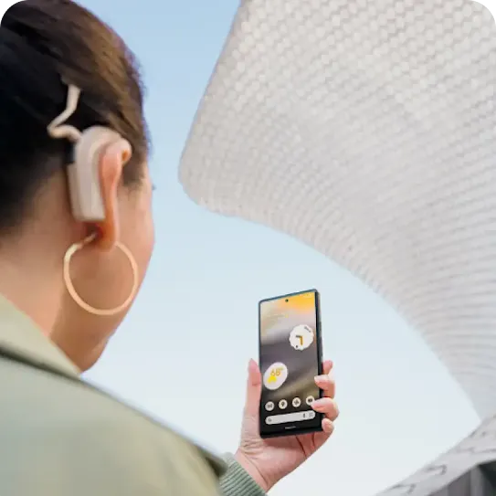 Person with a cochlear implant holds Android phone in front of them.