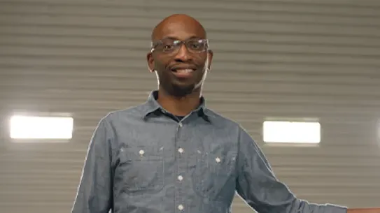 Founder Seyi Fabode smiles at the camera inside his garage-turned-office.