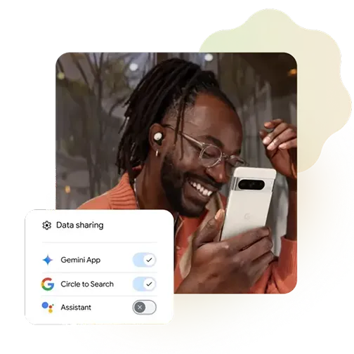 A man wearing glasses smiles while looking at his phone. A popup on the screen shows data-sharing settings, with toggles turned on for 