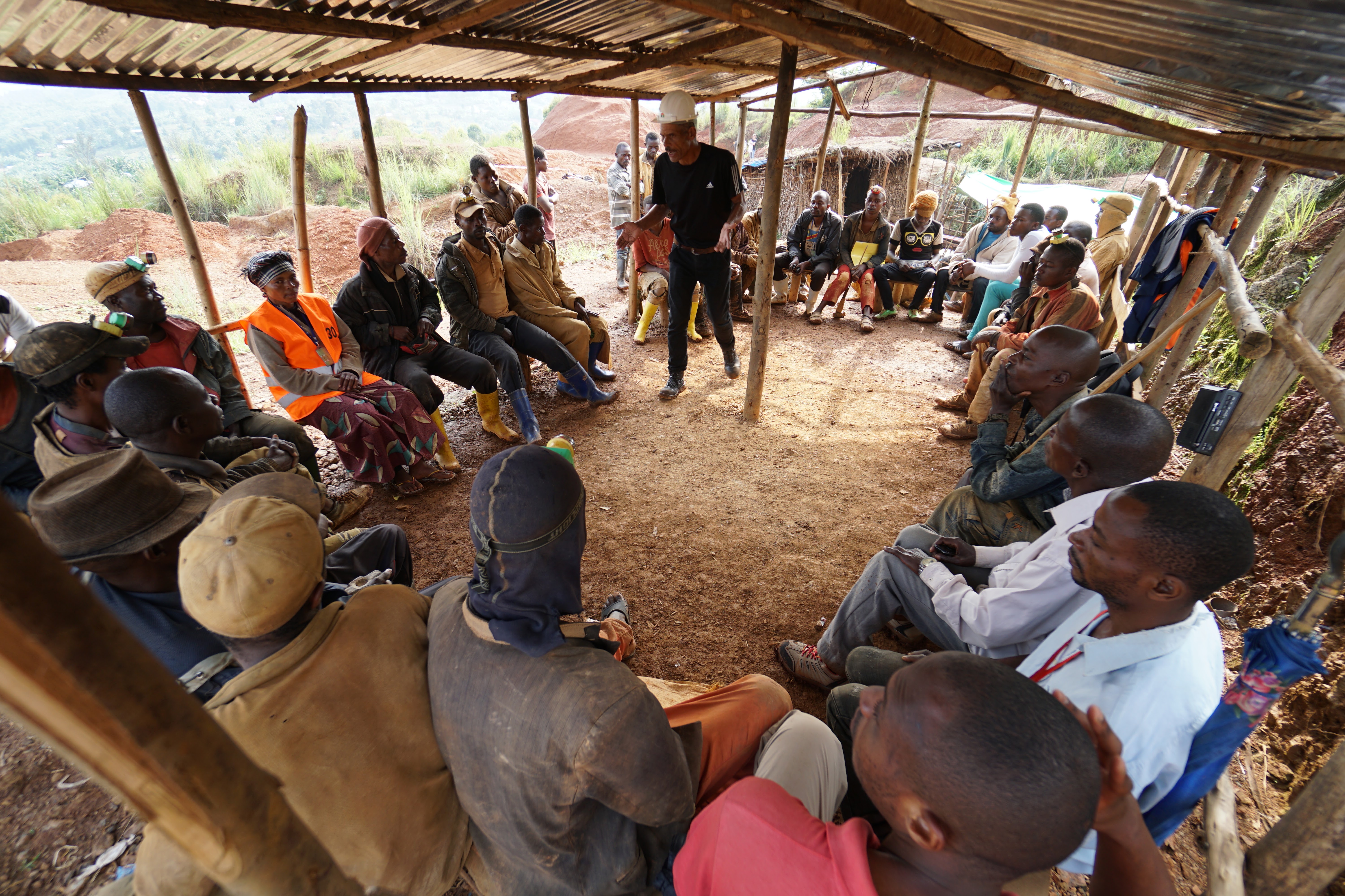 A person leads a morning discussion with fellow miners in the Democratic Republic of Congo.