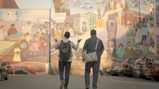 Founders, Justin and Bernard, are walking in front of a mural.