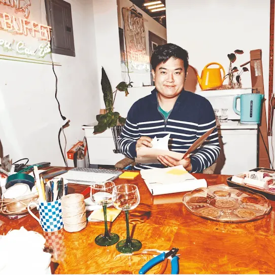 Man sitting at a desk, sorting through various papers
