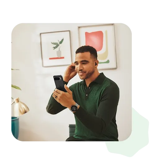 A person wearing a dark green, long sleeved shirt is adjusting one of their earbuds while taking a video call.