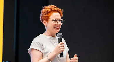 A female host, with a mic in hand, is delivering an excellent event.