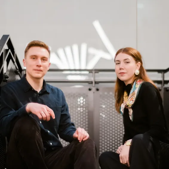 Ksenia Iliuk and Andriy Kusyy sitting side-by-side on a staircase