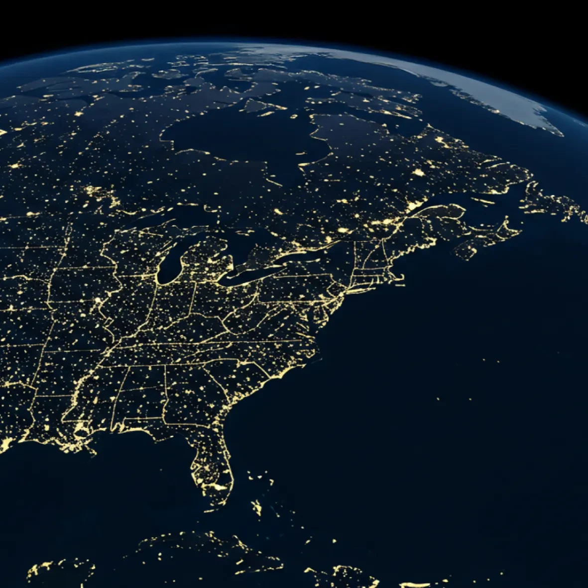 A dark image of North America and parts of Central America and the Caribbean at night, showing city lights illuminating the landmasses
