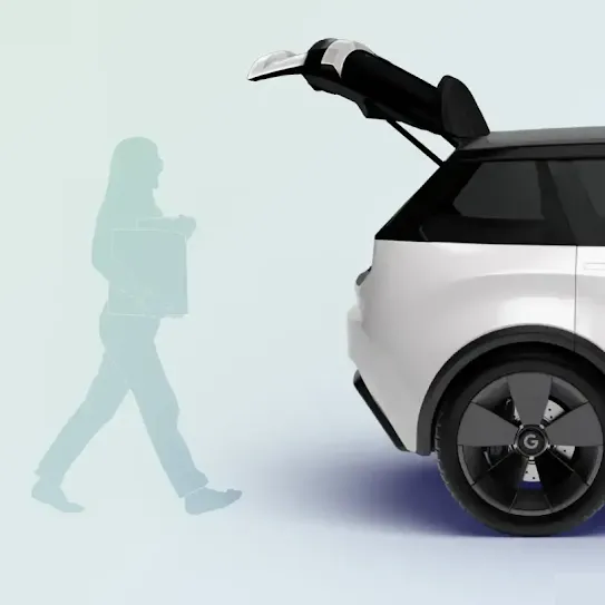 The silhouette of a woman carrying groceries approaches the open trunk of a car.