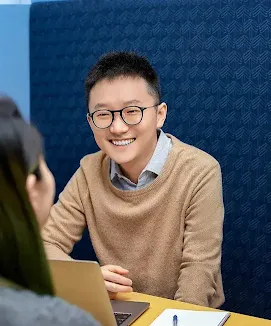 A man wearing spects looking at a women while their discussion.