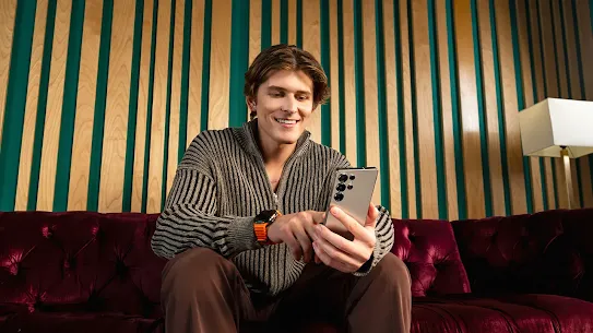 Man sitting holding Android phone