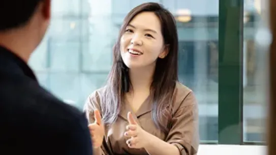 Founder Hanna Kim gestures to a colleague across a table.