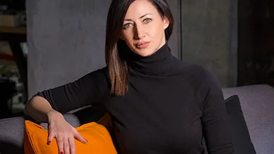 Founder Marija Ilic sits on a sofa facing the camera.