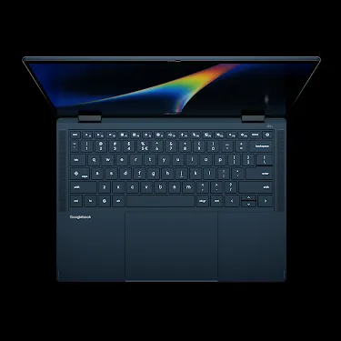 Googlebook laptop open, viewed from above, showing the keyboard and rainbow-gradient display.
