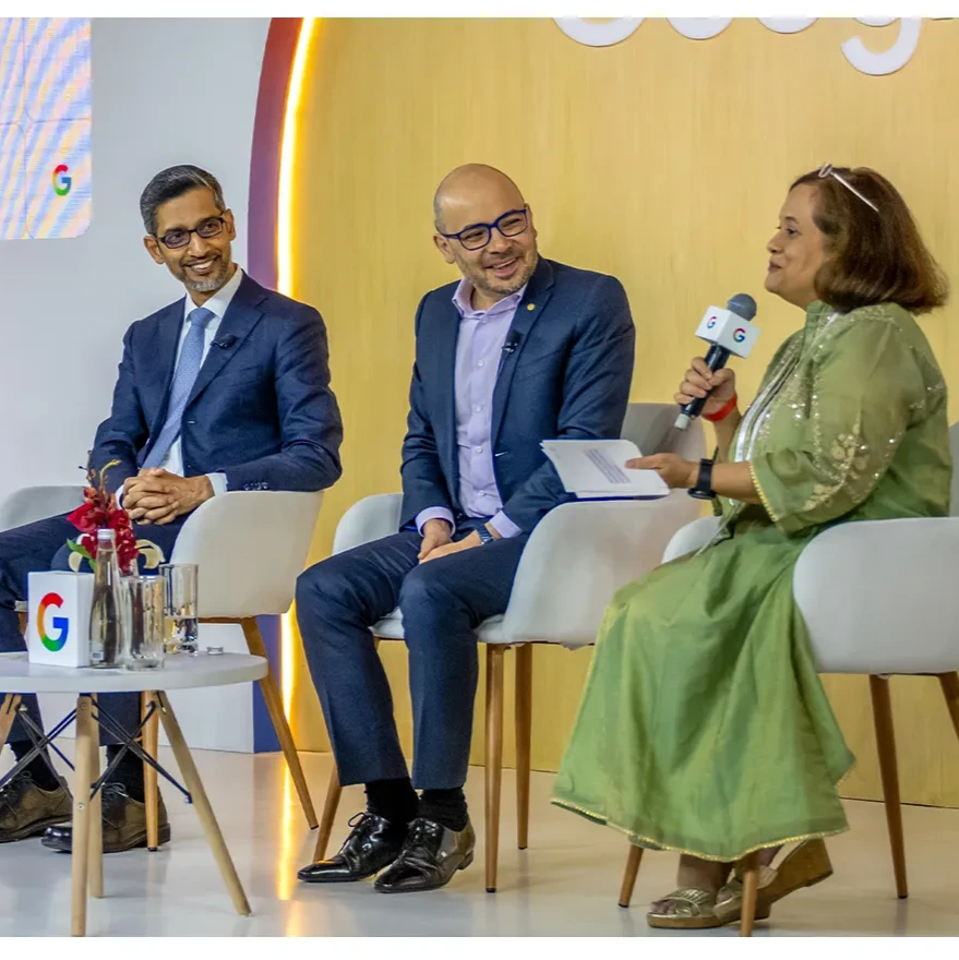 four people seated on a conference stage