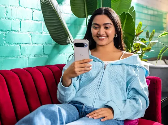 Woman sitting on couch with Android phone