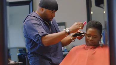 man cutting woman's hair in barber shop