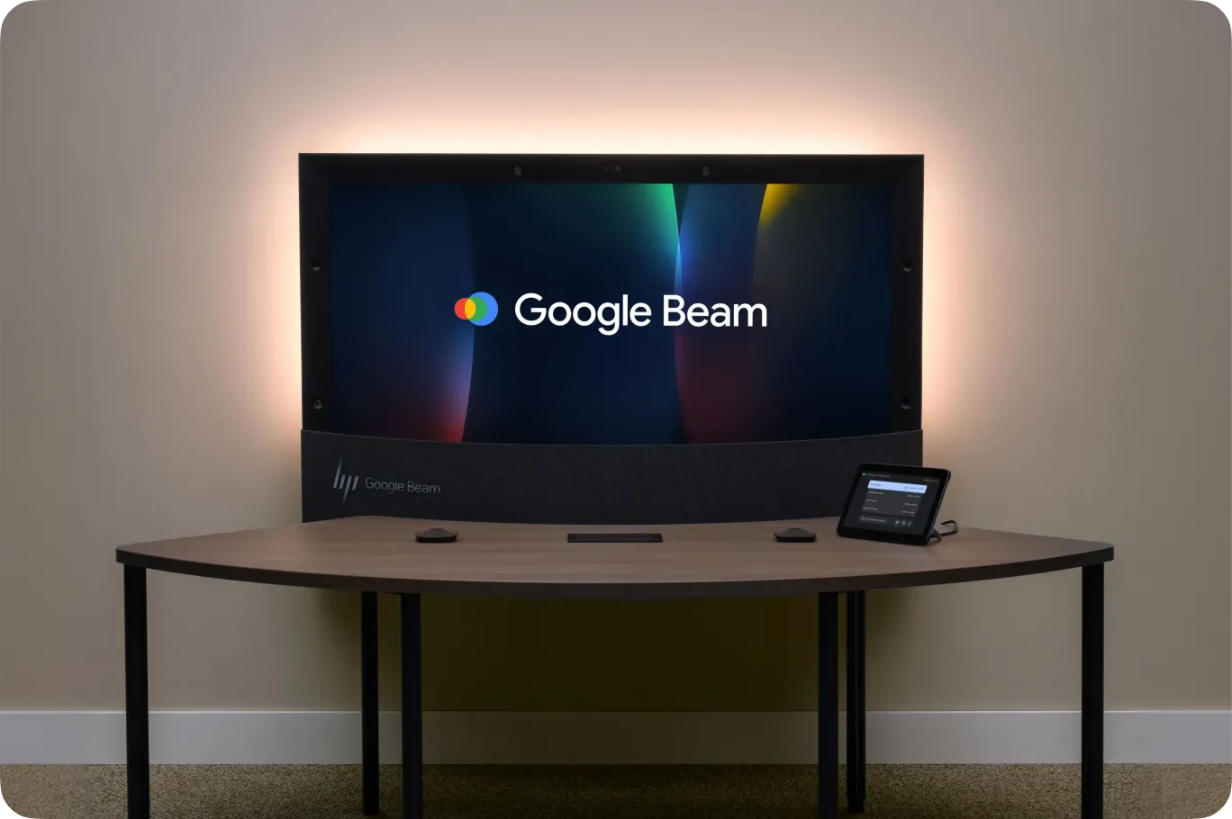 Wide-angle view of a Google Beam setup, highlighting the curved desk and ambient back-panel lighting.