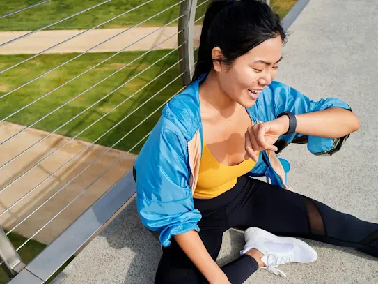 Woman sitting and looking at her smartwatch