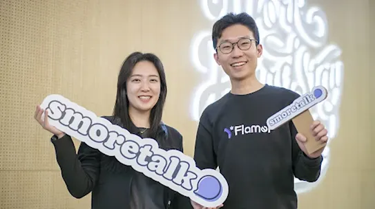 From L-R female co-founder Hyeonji Hwang and male co-founder Jeongmin Lee, posing with the Smoretalk signage