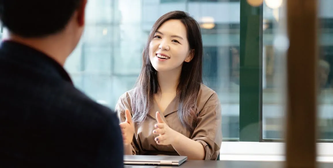 Founder Hanna Kim gestures to a colleague across a table.