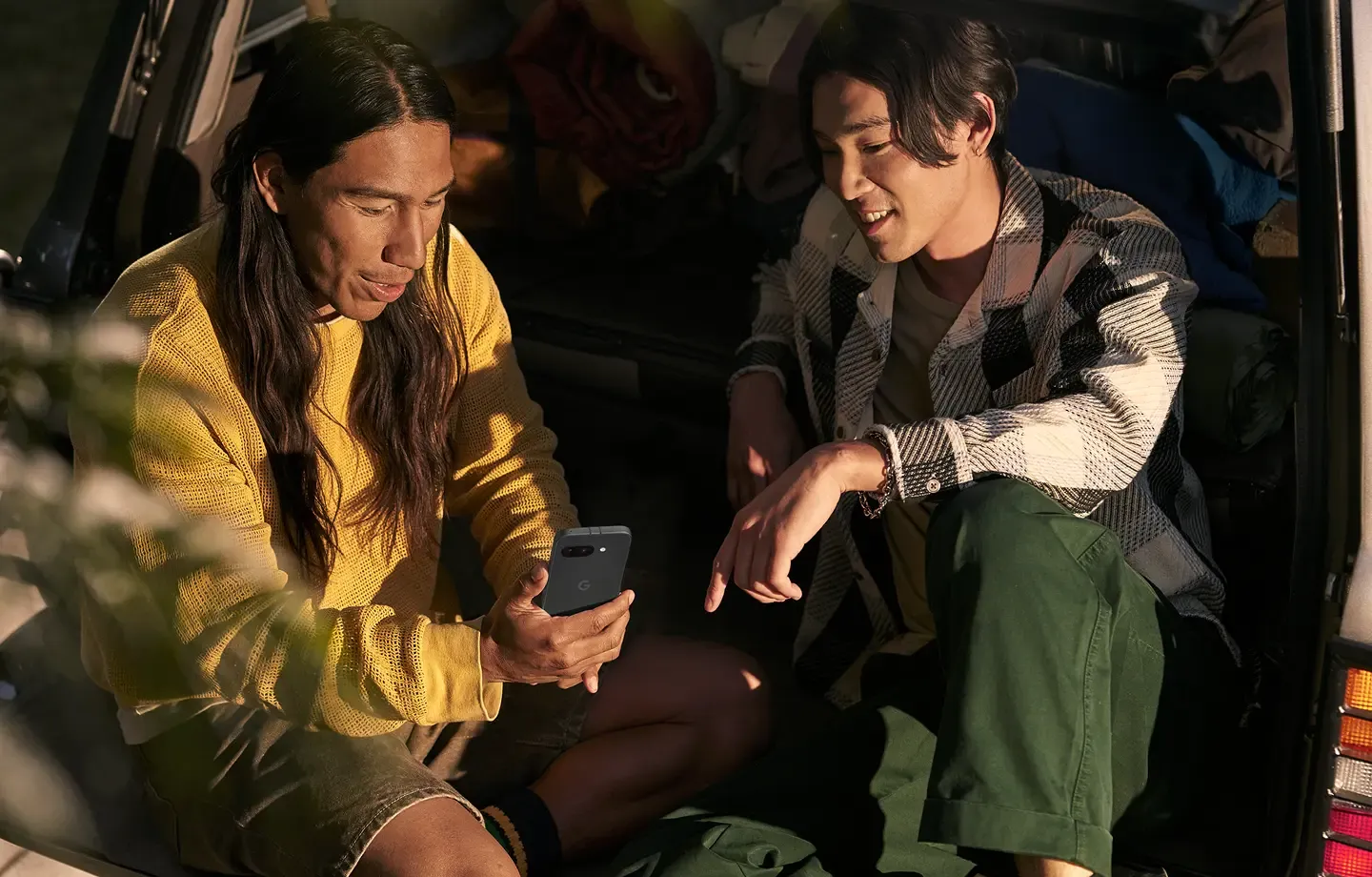 Two friends chatting while looking at a Google Android phone