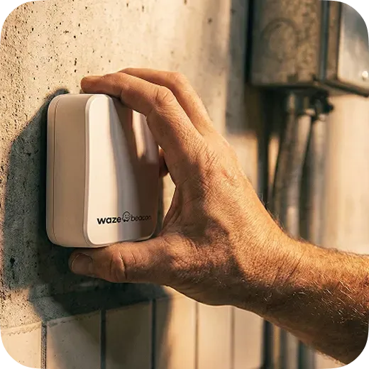 Hand installing a Waze Beacon Bluetooth hardware device on a tunnel wall for underground navigation
