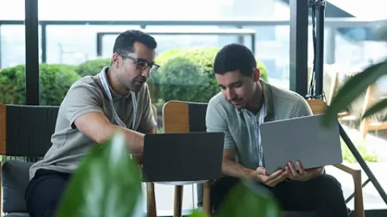 Two colleagues collaborating over code, turning ideas into solution.