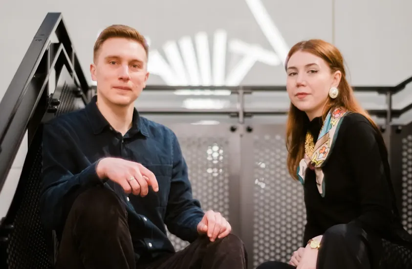 Ksenia Iliuk and Andriy Kusyy sitting side-by-side on a staircase