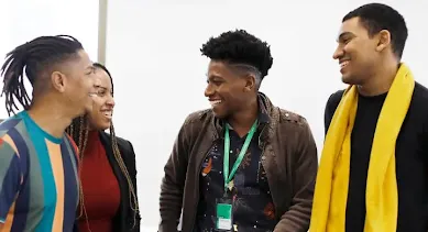 Man wearing an Identity card talking to a group of people.
