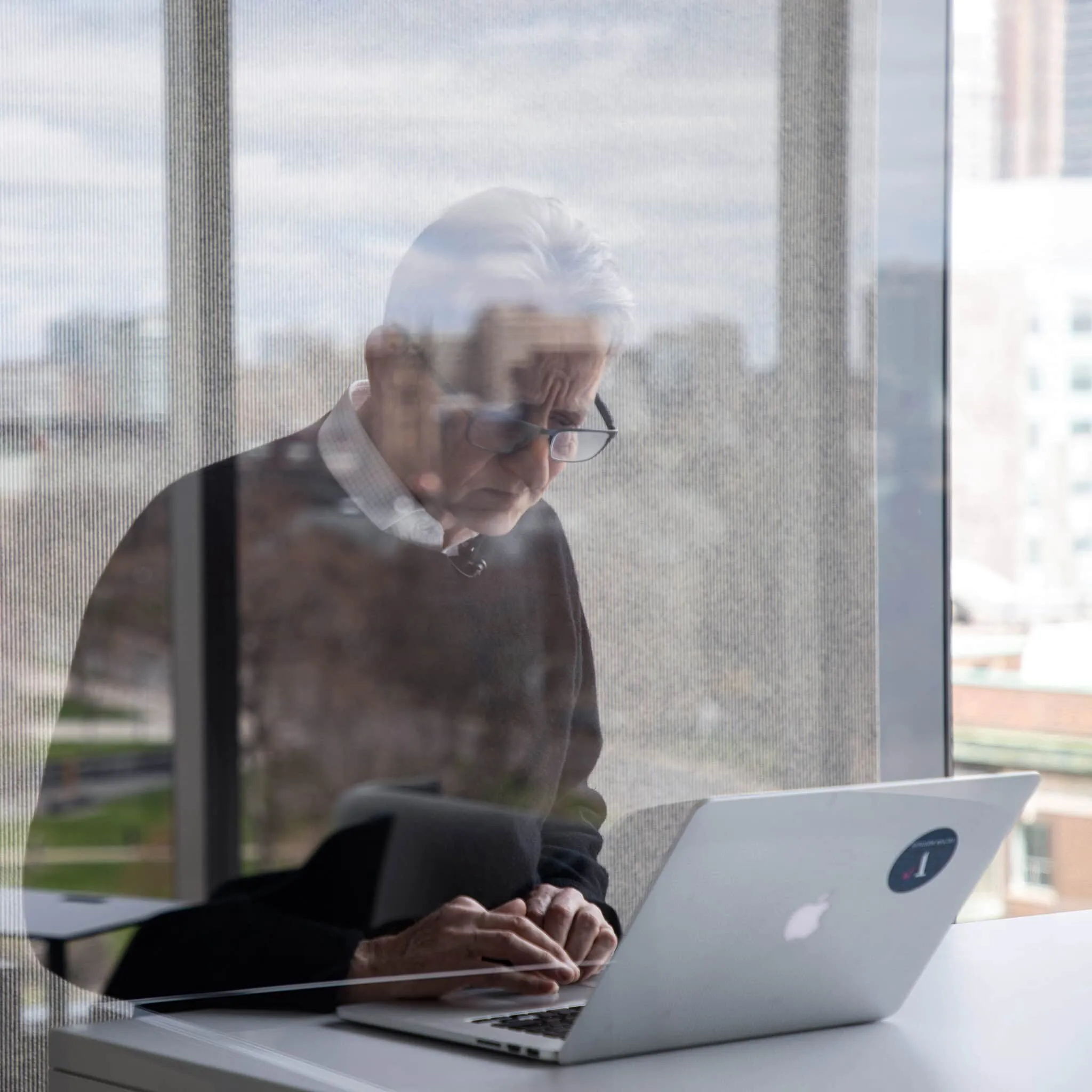 Geoffrey Hinton working at a laptop