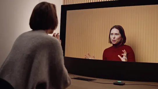 Two people communicating expressively during a Google Beam video meeting.