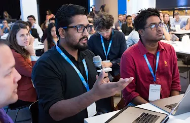 An audience member with a mic questioning the host.