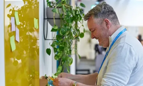 A man is smiling by looking at a board