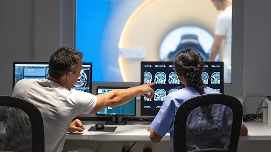 A photograph of radiologists analyzing medical imagery in a diagnostic suite, used to illustrate the Bayer case study. The image highlights the collaboration between healthcare experts and AI-driven tools to enhance the accuracy and efficiency of medical imaging, specifically in the development of automated solutions for detecting complex conditions.
