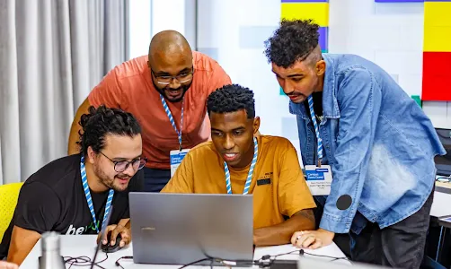Quatro pessoas olhando para um laptop