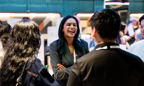 Three people smiling warmly while having a pleasant conversation.