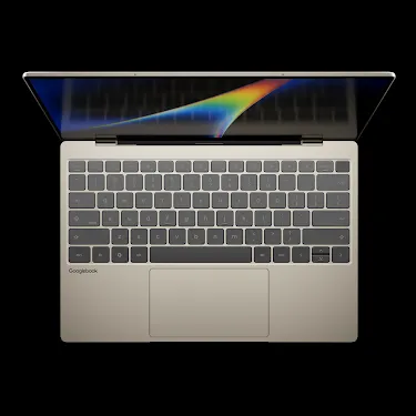 Googlebook laptop open, viewed from above, showing the keyboard and rainbow-gradient display.